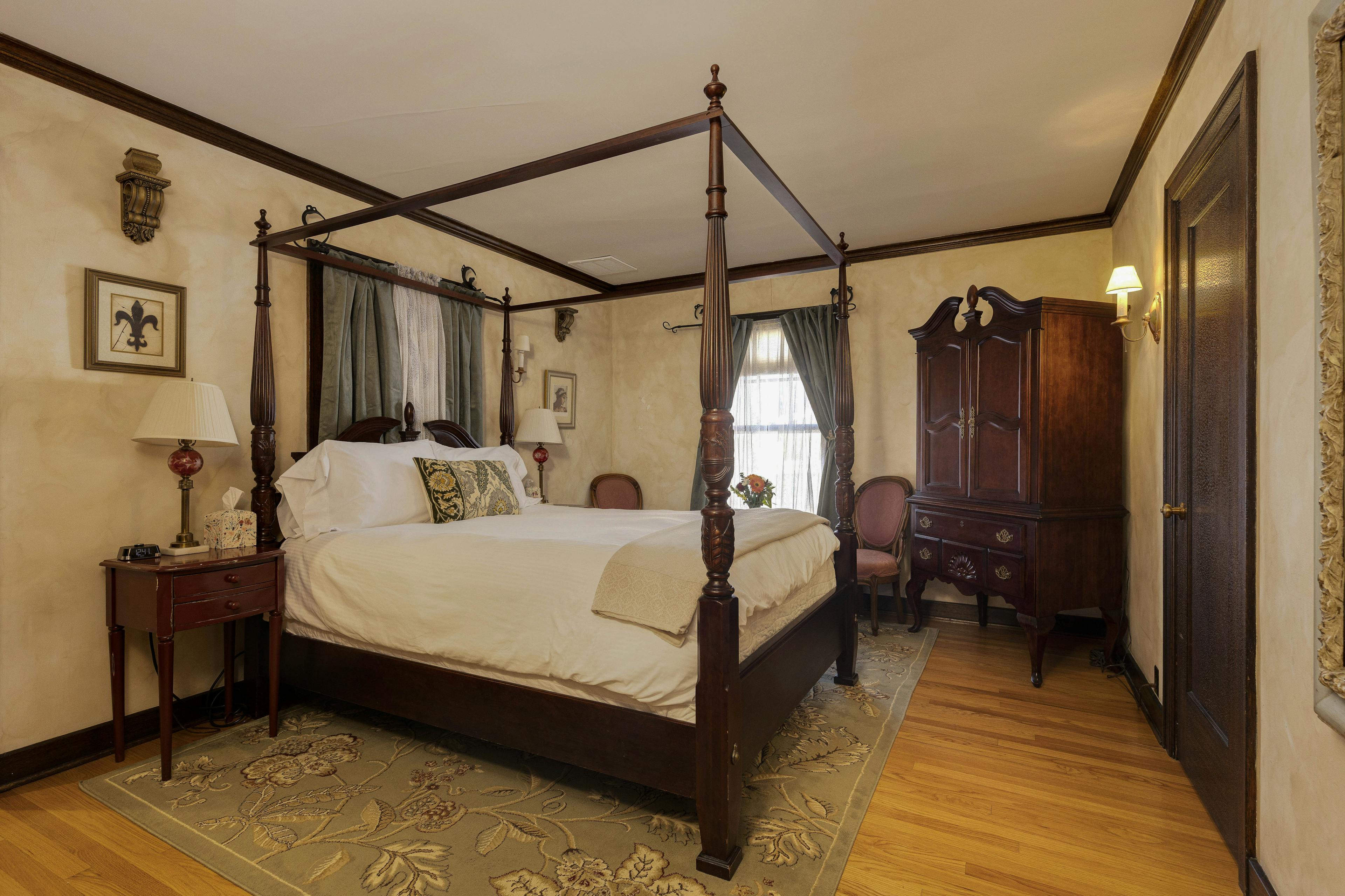 A Napoli Guest Room with a four-poster bed, ornate furniture, and soft lighting.