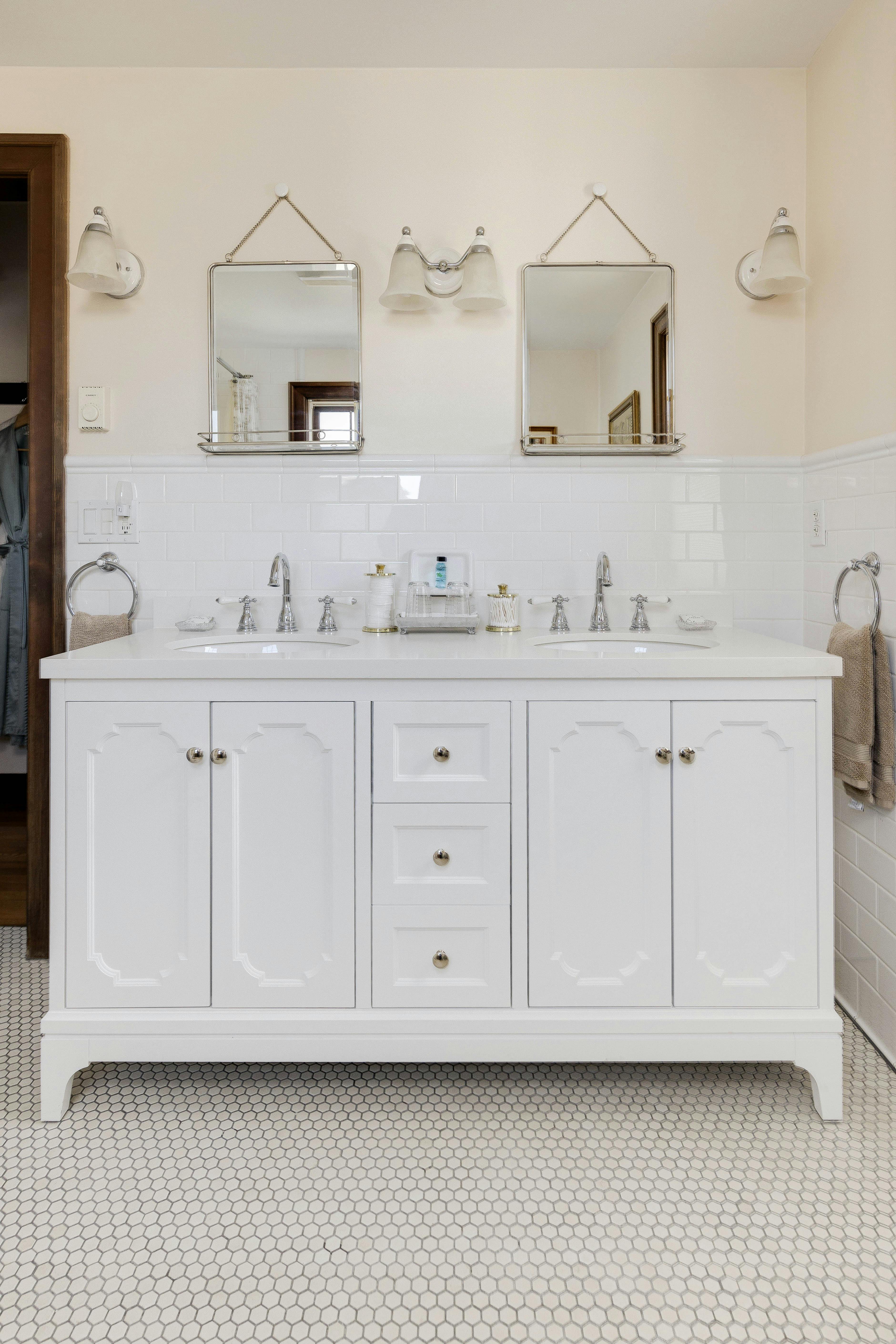 The Napoli Guest Room vanity with dual sinks, white cabinets, and framed mirrors above.