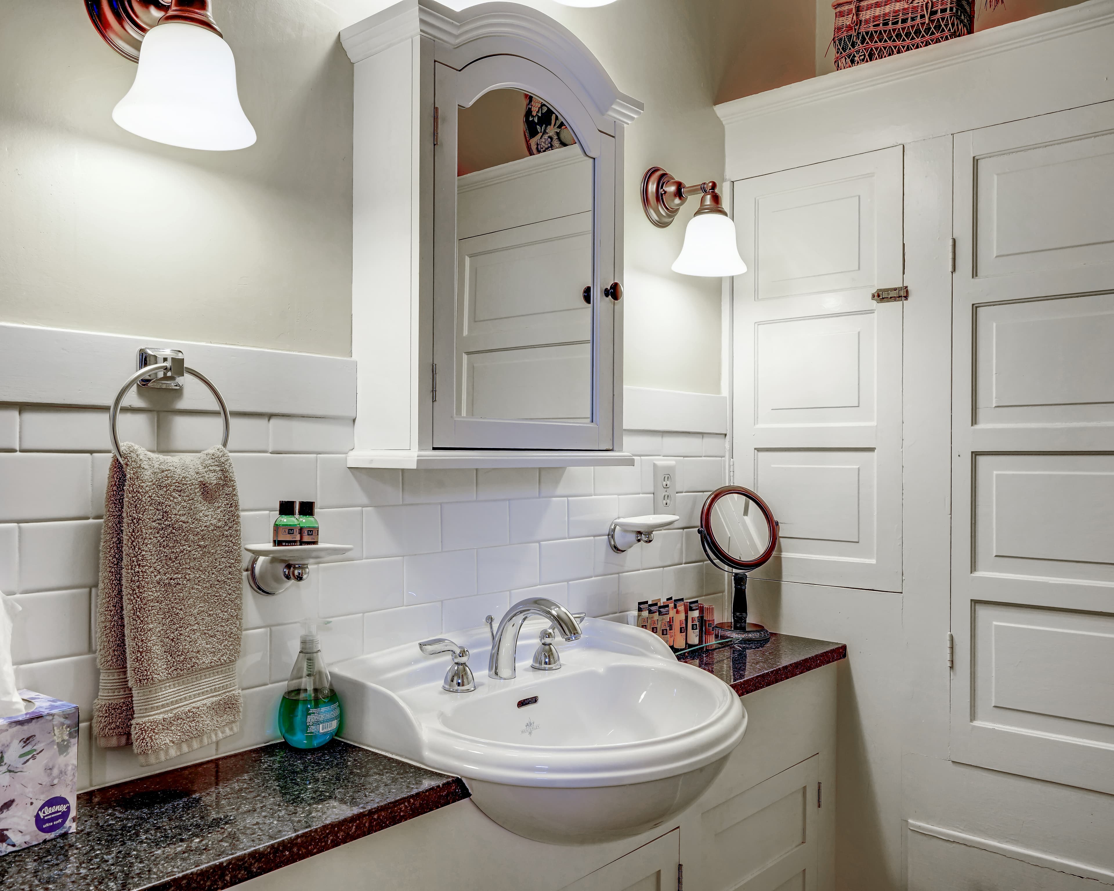 View of bathroom vanity, sink, mirror and built in linen cabinets.