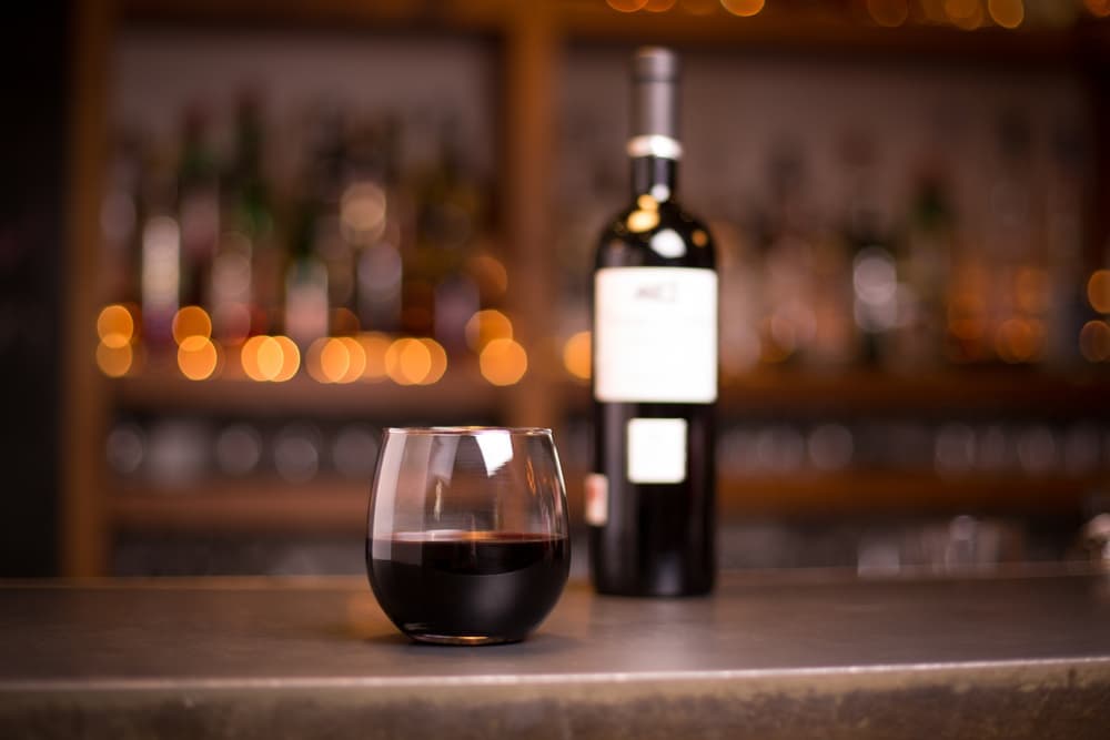 a stemless glass of red wine, enjoying a tasting at the top wineries in Oregon near our Bed and Breakfast in McMinnville