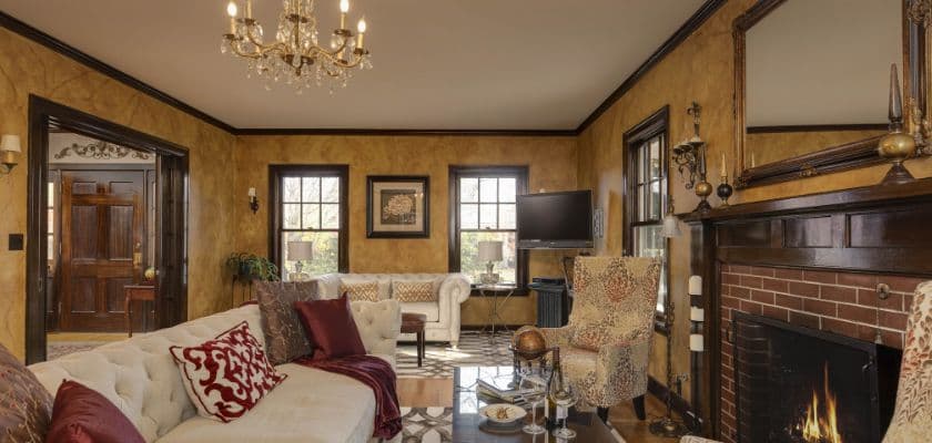 A cozy living room with a fireplace, elegant furniture, and a chandelier.