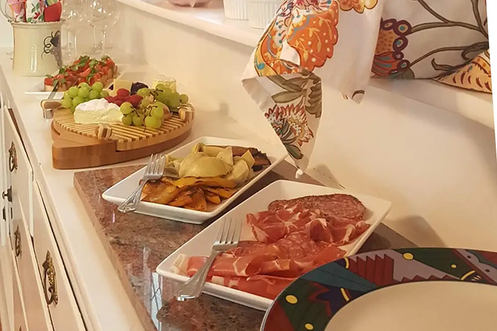A beautifully arranged charcuterie spread featuring meats, cheeses, grapes, and fruits on a countertop.