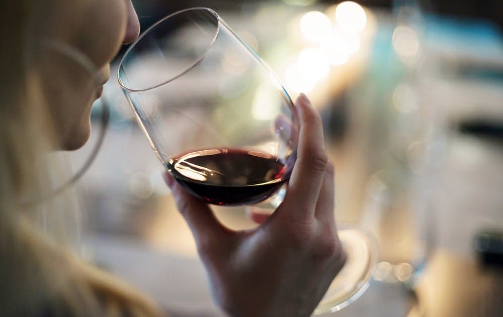 A person holding a glass of red wine.