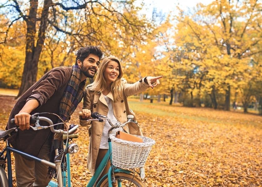 couple pointing while on autumn bike ride
