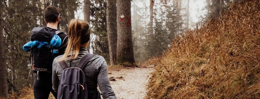 a couple on a winter hike in the woods