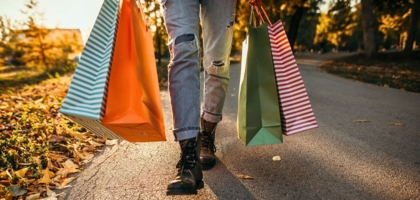 person walking with shopping bags in autumn
