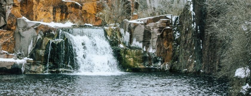 a winter waterfall with a snow-dusted rocky ledge
