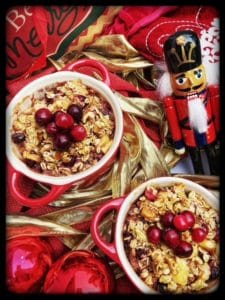 Baked Spiced Oatmeal with Apples, Cranberries and Walnuts served in red crocks amidst holiday decorations of red bulbs, stockings and a nutcrakcer.
