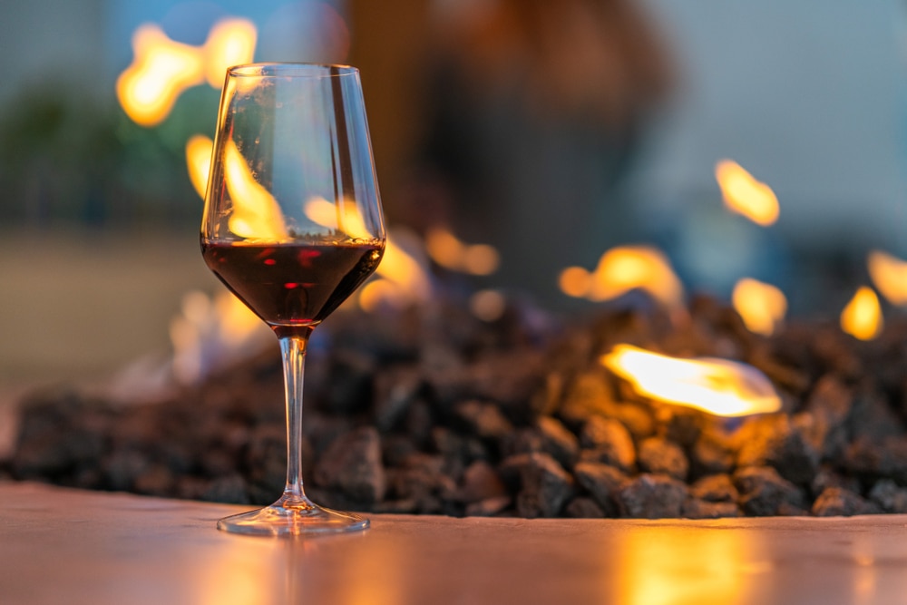Glass of red wine by the fire - a cellar season treat at Willamette Valley wineries that can be enjoyed by staying at our McMinnville Oregon Bed and Breakfast