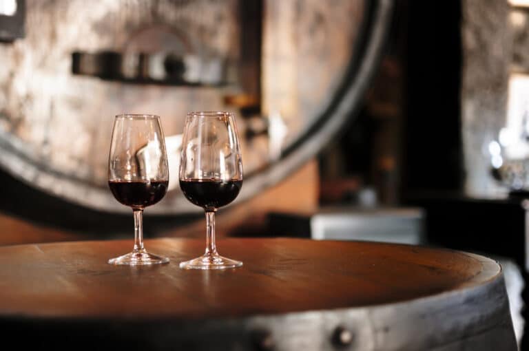 Two glasses of wine on barrels, enjoyed during Willamette Valley wine tours